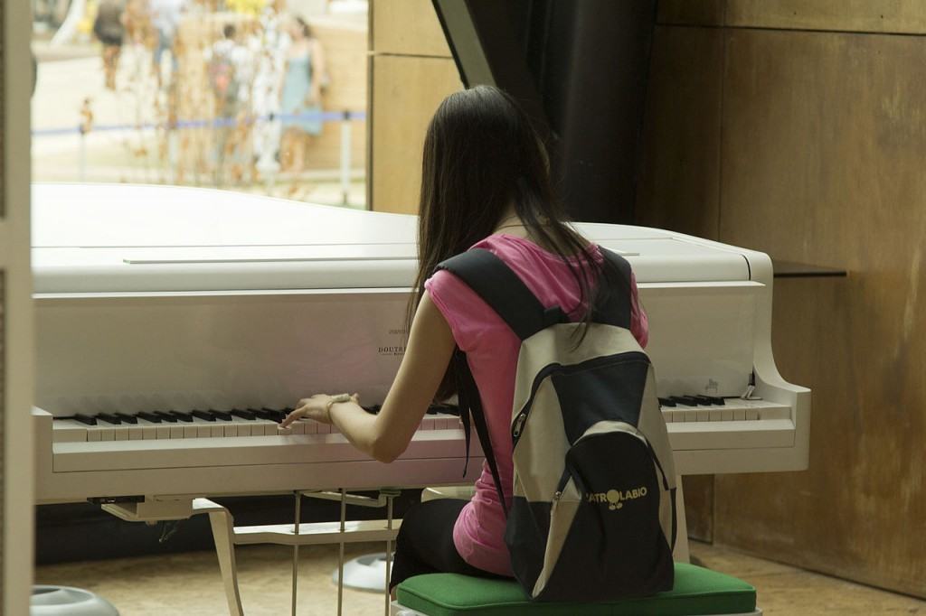 girl playing grand piano