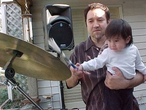 dad teaching child to play drums