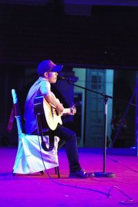 man plays guitar while singing