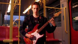 man playing the guitar on a bus