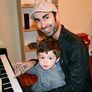 father and son playing the piano