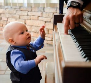 little boy trying to play the piano