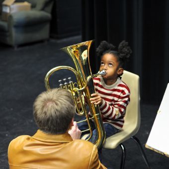 child being taught to play an instrument