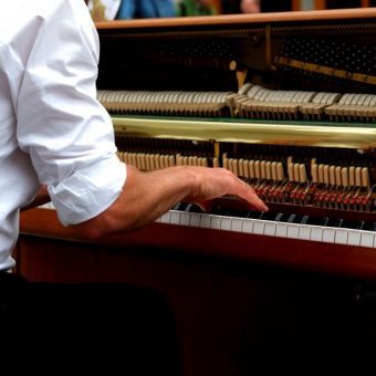 someone playing a brown upright piano