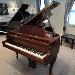 Wide picture of a Chickering and Sons Louis XV style Baby grand piano in satin mahogany