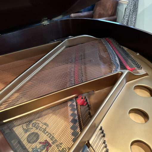 Detail image of the interior of a vintage Chickering and Sons Louis XV style baby grand piano in satin mahogany