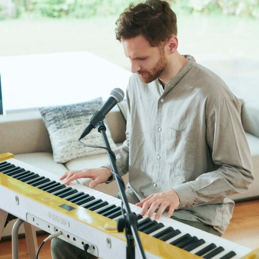 Image of a Man using a microphone with a Casio PX-S7000 in Mustard