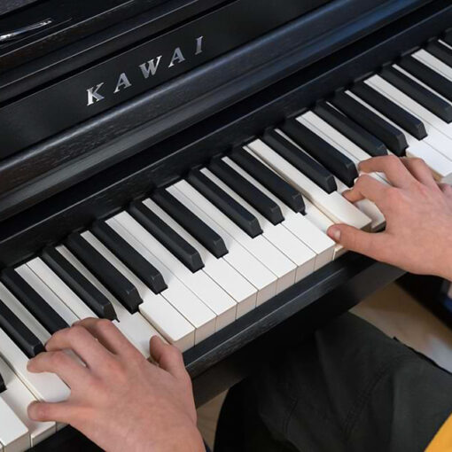 Close up photo of someone's hands playing the keys of a Kawai CA401 digital piano.