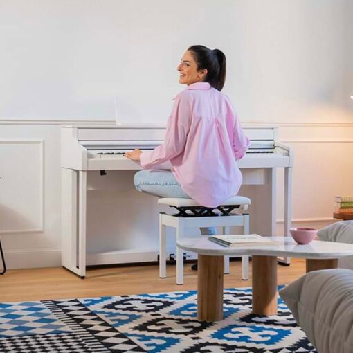 Image of woman in pink shirt playing a white Kawai CA501